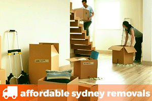 a man carrying a removalist box up a staircase with a woman packing another removalist box
