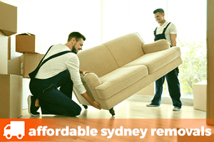 two removalists lifting a lounge to be moved to a new home
